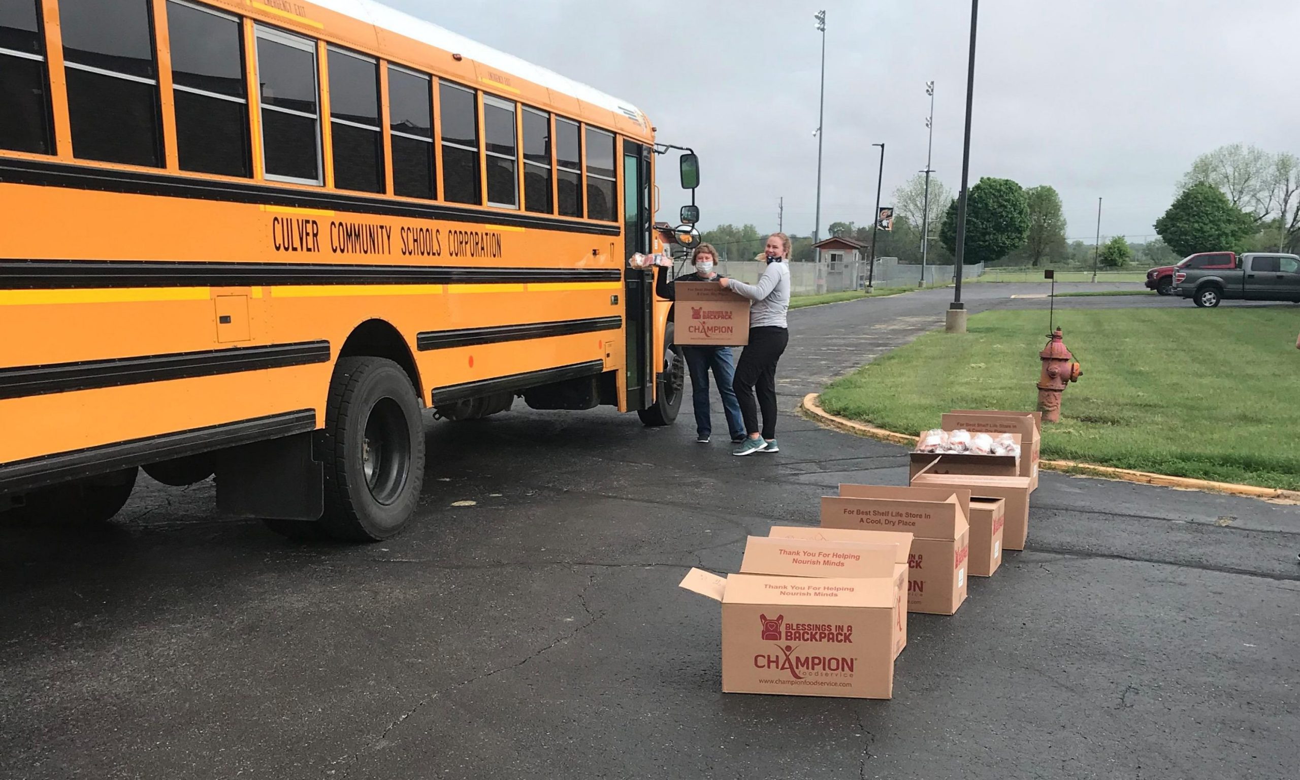 Back to School Volunteers putting boxes of food on the bus