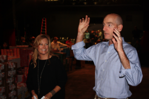 Tabitha and Jim Furyk address and thank the group of volunteers prior to the beginning of the packing process. Photo by Jon Blauvelt