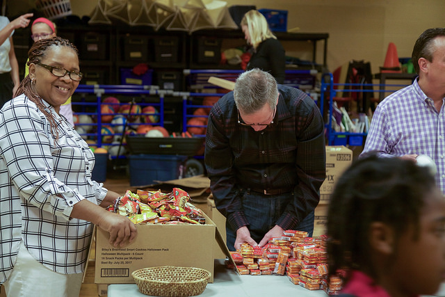 Volunteers preparing to fill bags of food for the kids