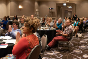 Attendees applaud a presentation