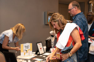 Volunteer Conference attendees looking over Blessings in a Backpack merchandise