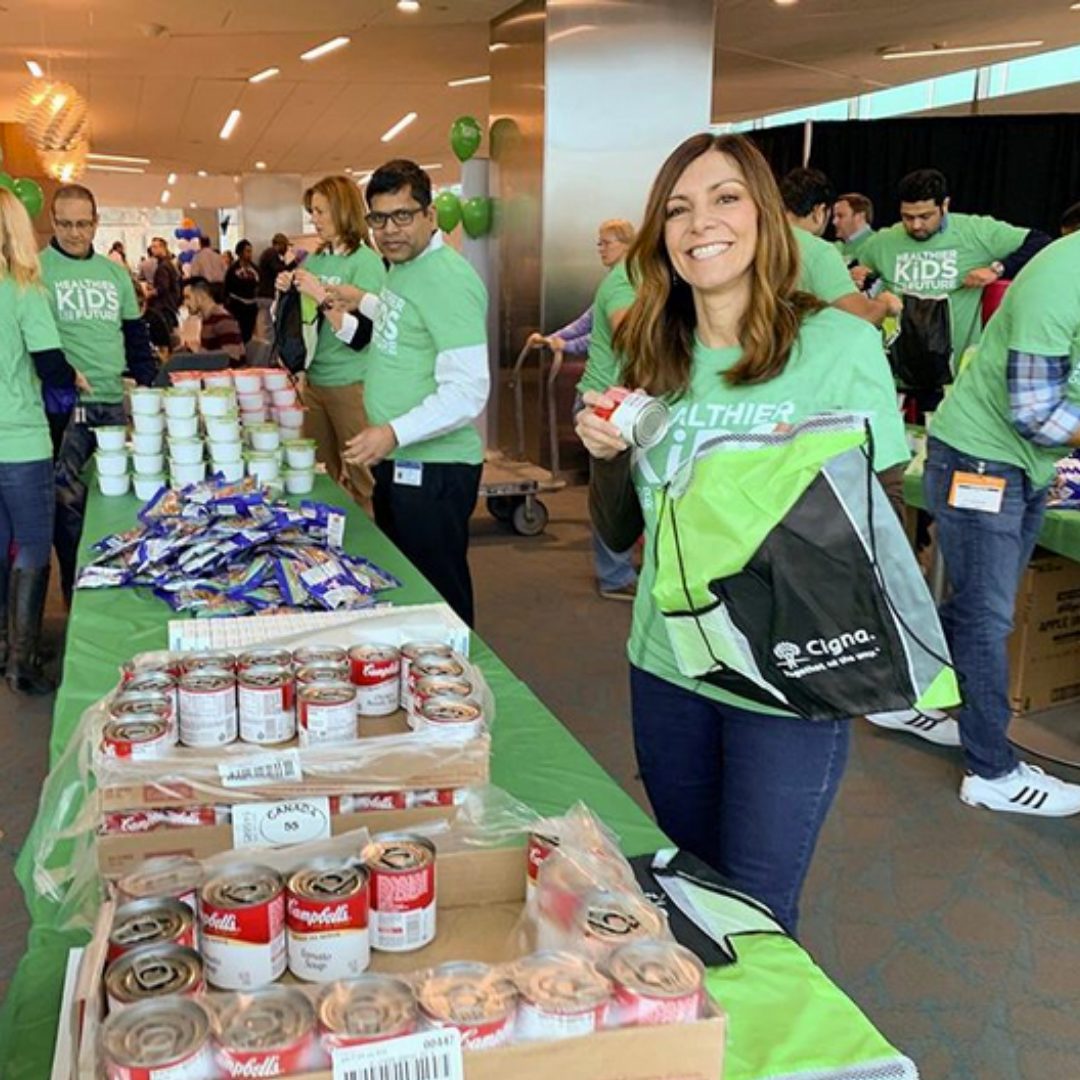 Cigna employees pack bags of food