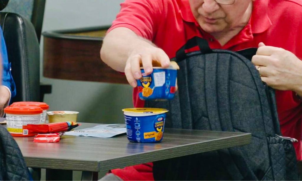 senior man putting food in backpack