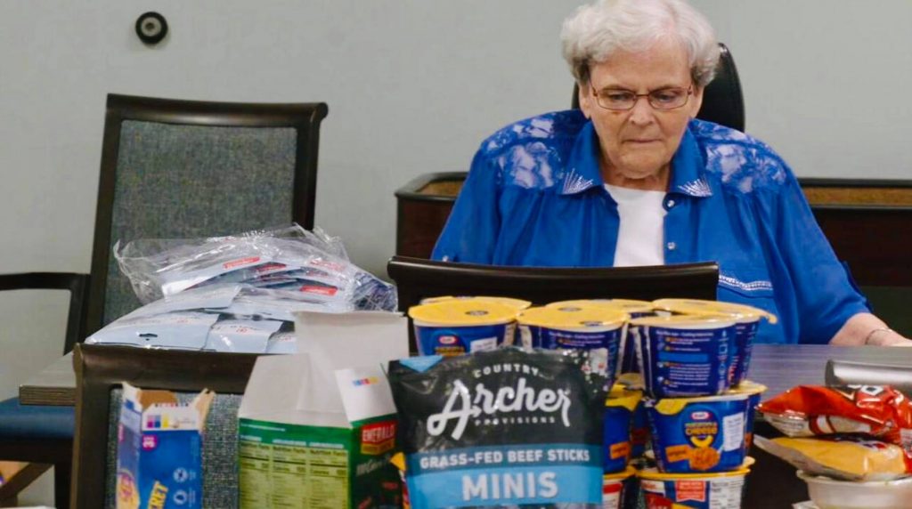 senior woman putting food in backpack