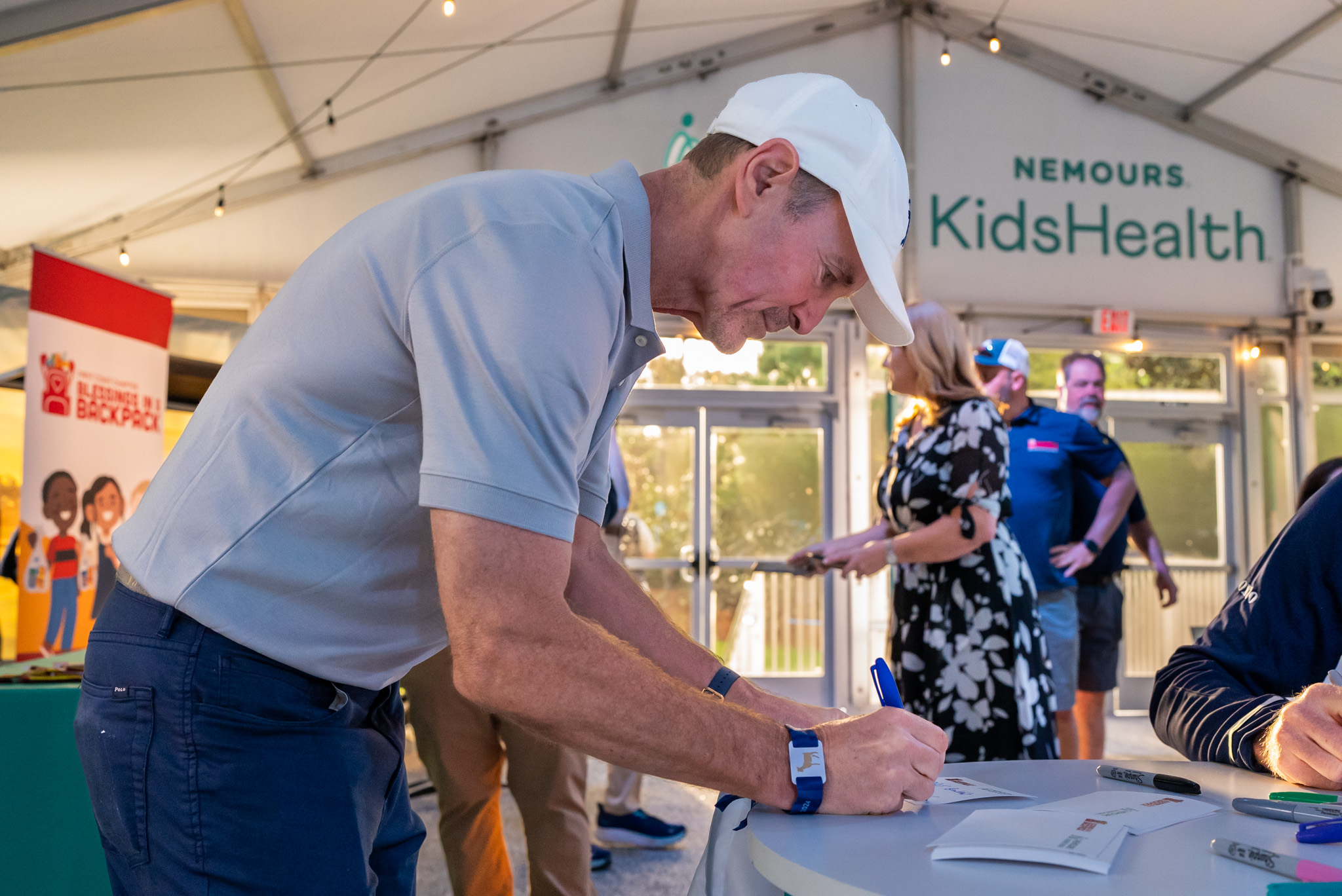 PGA golfers and volunteers writing note cards for kids