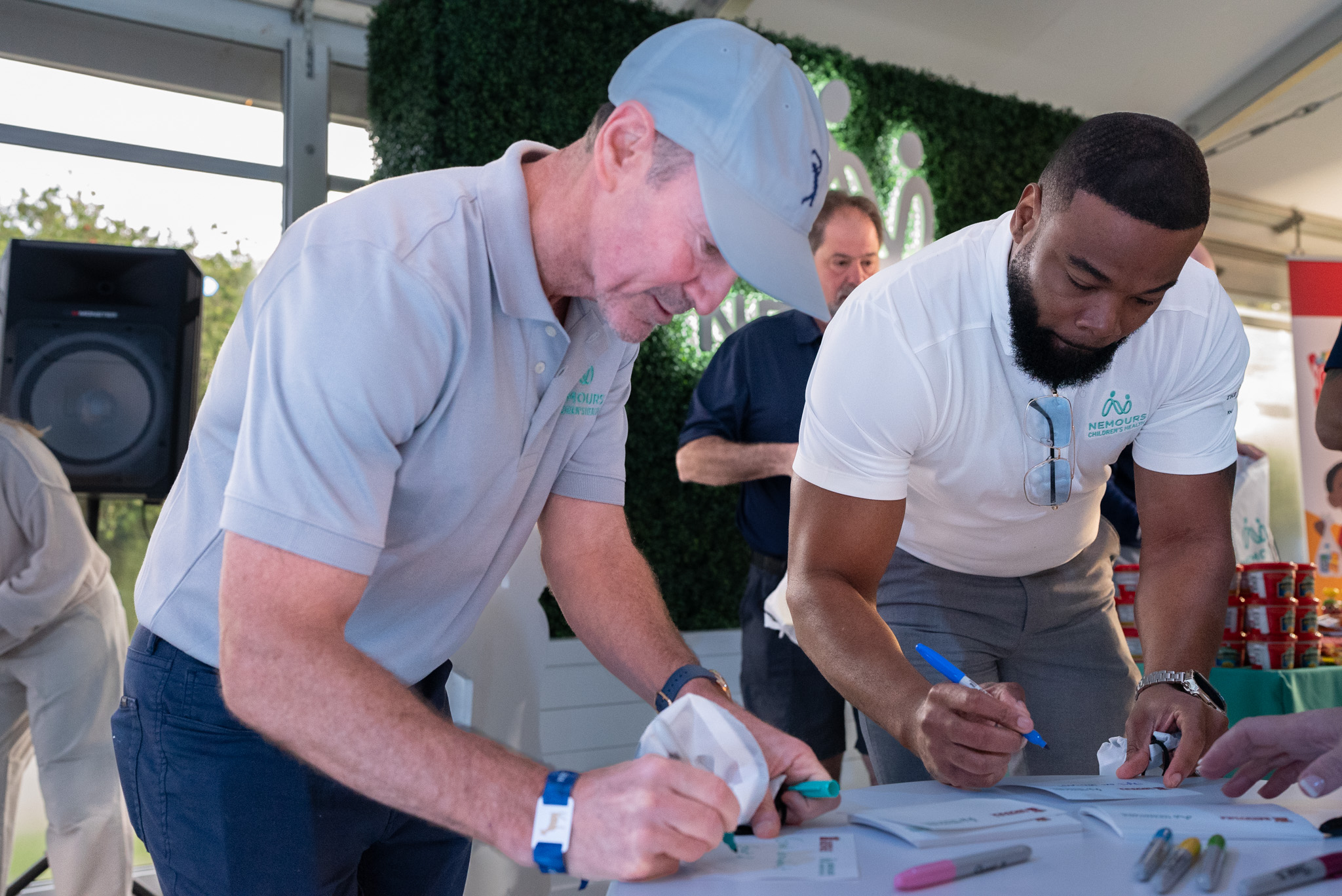 PGA golfers and volunteers writing note cards for kids