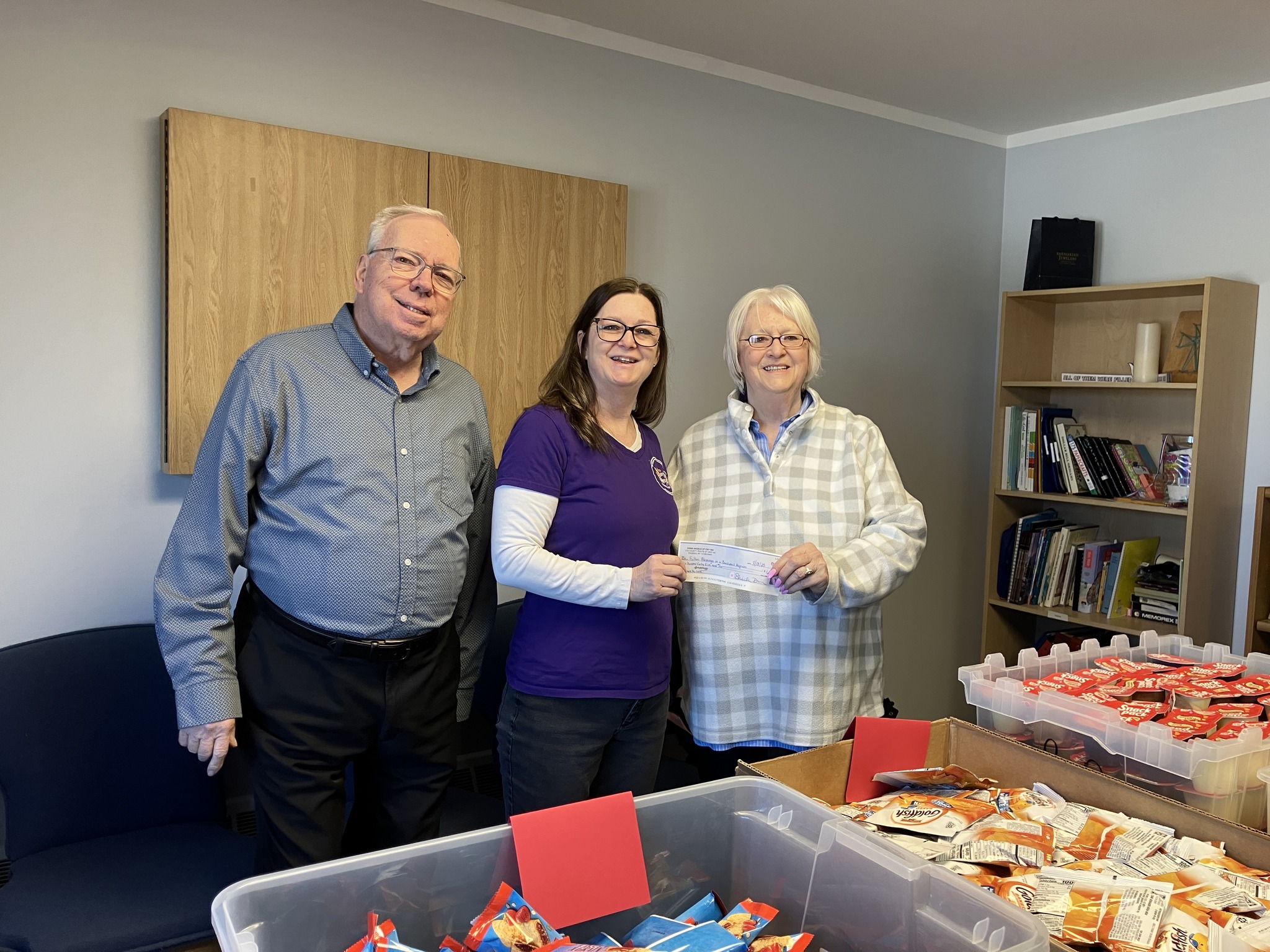 Fulton Program people smiling and holding a check, on man and two women
